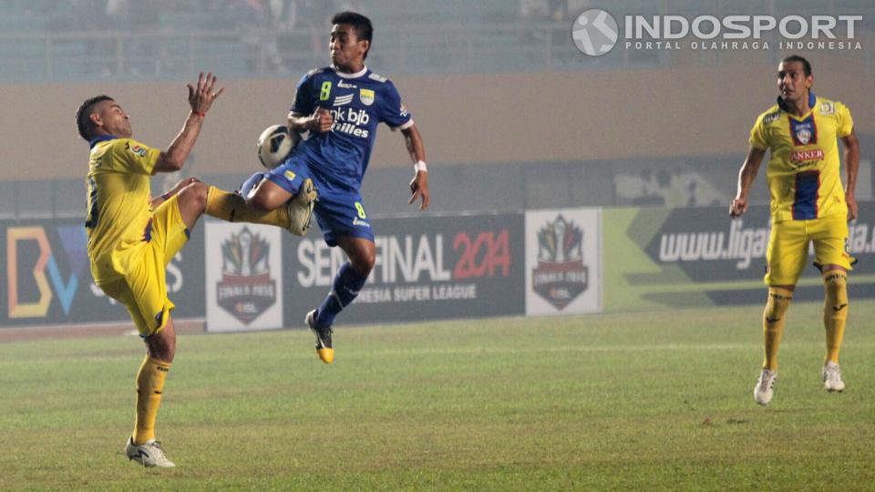 Cristian Gonzales (kiri) berduel memperebutkan bola dengan gelandang Persib M. Taufik.